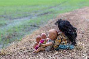 hinter der Gruppe von Babypuppen, die auf trockenem Gras sitzen. foto