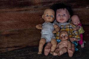 eine Gruppe von Babypuppen, die in einem alten Holzhaus sitzen. foto