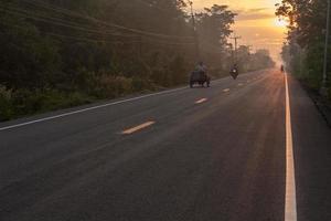 Asphaltstraße mit Sonnenaufgang auf dem Land. foto