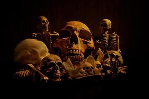 Stilllebenkunst eines menschlichen Schädels und eines Knochenhaufens auf schwarzem Hintergrund foto