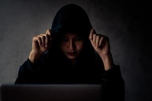 Junge asiatische Hacker finden persönliche Informationen im Internet und machen damit illegal Geld foto