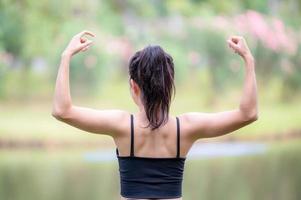 eine schöne asiatische frau wärmt sich auf, um die muskeln flexibel zu machen, bevor sie zum joggen geht foto