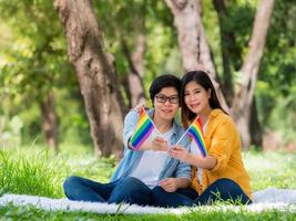 asiatische paare zeigen das lgbt-symbol und umarmen sich mit liebe und glück foto