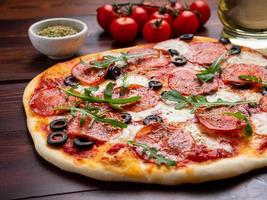 heiße hausgemachte italienische Peperoni-Pizza mit Salami, Mozzarella und Oliven foto