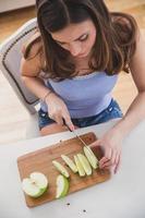 junge Frau schneidet Apfel. Bild von oben. foto