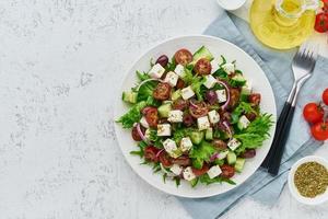 griechischer salat mit feta und tomaten, nährendes essen auf draufsicht des weißen hintergrundkopienraums foto