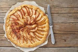 apfelkuchen, galette mit früchten, süßes gebäck auf altem rustikalem holztisch, draufsicht, kopierraum foto