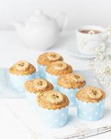 bananenmuffin, cupcakes in blauem kuchenförmchenpapier, weißer betontisch