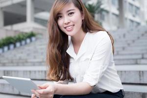 asiatische Studentin mit Tablette auf dem Campus