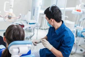 Zahnarzt, der eine Patientin heilt foto