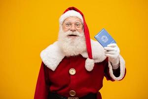 weihnachtsmann, der einen brasilianischen pass hält. neujahrsreisekonzept. Weihnachtsmann am Flughafen. foto