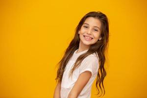 Porträt eines glücklich lächelnden Mädchens im gelben Hintergrund.
