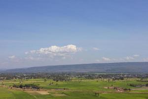 ein Panoramablick auf die Hügel mit Dörfern, Bäumen und Reisfeldern mit Wolken am Himmel. foto
