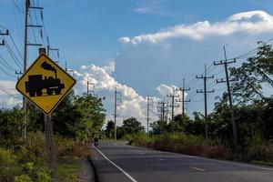 Blick auf die Landstraße mit Warnschildern über die Eisenbahn. foto