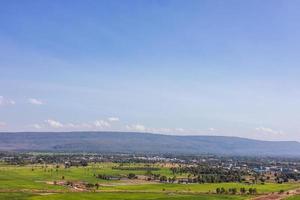 ein Panoramablick auf die Hügel mit Dörfern, Bäumen und Reisfeldern mit Wolken am Himmel. foto