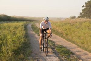 junger Sportler, der auf seinem professionellen Mountainbike oder Cyclocross-Fahrrad im Wald fährt foto