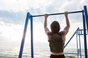 junger bärtiger athlet training im freien mit gewichtsweste, übung mit militärischem plattenträger foto