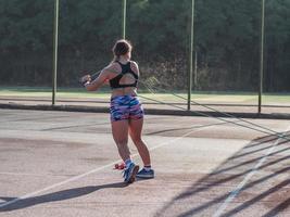 Junge starke Frau, die im Sommer im Freien trainiert, weibliche Profisportlerin macht Übungen im Park foto