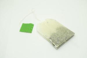 Teebeutel mit grünem Etikett. isoliert auf weißem Hintergrund. Nahaufnahme des Teebeutels. foto