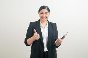 asiatische Frau, die Tablette mit weißem Hintergrund hält und verwendet foto