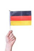 eine hand hält die flagge die flagge deutschlands auf einem weißen hintergrund isoliert. foto