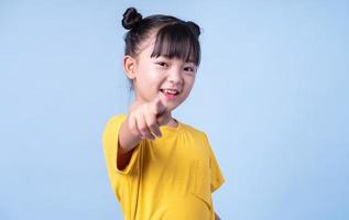 Bild eines asiatischen Kindes, das auf blauem Hintergrund posiert foto