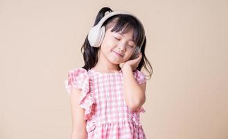 Bild des asiatischen Kindes, das Musik im Hintergrund hört foto