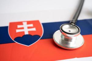 schwarzes Stethoskop auf slowakischem Flaggenhintergrund, Geschäfts- und Finanzkonzept. foto