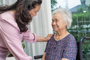 Hilfe und Pflege asiatische Senioren oder ältere Frauenpatienten, die im Rollstuhl auf der Krankenstation sitzen, gesundes, starkes medizinisches Konzept foto