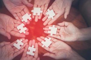 Hand verschiedener Menschen, die ein Puzzle verbinden. konzept der partnerschaft und teamarbeit im geschäft foto