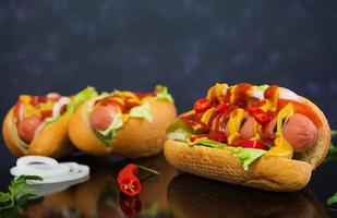 köstlicher hausgemachter Hotdog auf dunklem Hintergrund foto
