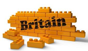 britisches Wort auf gelber Backsteinmauer foto