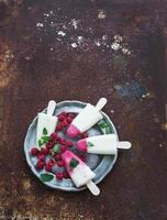 Himbeer-Limetten-Yougurt-Eis oder Eis am Stiel mit frischen Beeren foto