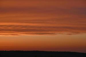 roter und blauer Abendsonnenuntergang über dem Wald foto