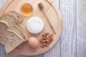 Frischkäse, Honig, Ei und Brot auf einem Teller foto