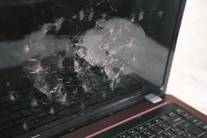 zerbrochener Laptop-Bildschirm auf dem Tisch aus nächster Nähe foto