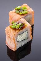 Sushi-Rolle mit Zwiebeln auf einer Steinpastete foto