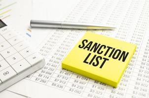 Sanktionsliste grauer Hintergrund. zwei Notizbücher und eine Erbsenpflanze foto