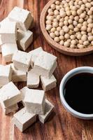 Stück Tofu und Sojabohnen auf einem Schneidebrett foto