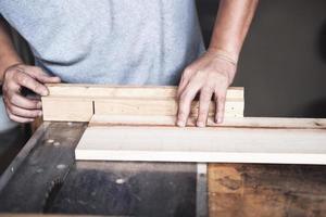 Holzverarbeiter verwenden Sägeblätter, um Holzstücke zu schneiden, um Holztische für ihre Kunden zusammenzubauen und zu bauen. foto
