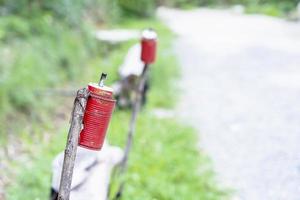 Nahaufnahme einer alten brennenden Öllampe aus einer Dose auf dem Weg mit natürlichem Hintergrund. Öllampen in Dosen recyceln foto