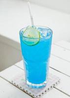 blauer Cocktail auf weißem Tisch