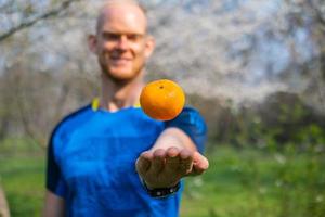 Männchen mit Mandarine in der Hand hautnah foto