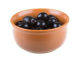 Oliven schwarz mit Olivenöl in einer Schüssel auf einem weißen Hintergrund bewässert foto