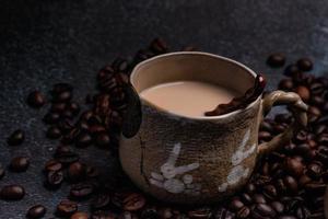 Zwei Tassen Kaffee mit Kaffeebohnen auf dunklem Hintergrund. foto