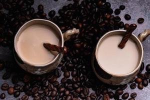 Zwei Tassen Kaffee mit Kaffeebohnen auf dunklem Hintergrund. foto