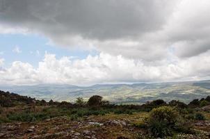 Blick von einem Hügel auf die Berge mit Wolken foto