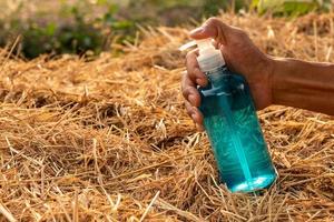 Finger mit einer blauen Gelflasche auf einem Strohhalm. foto