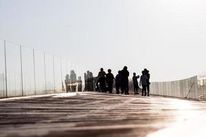 Silhouettenmenschen auf der alten Holzbootbrücke. foto
