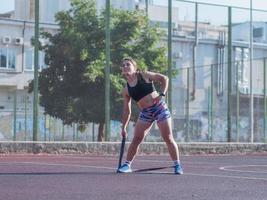 Junge starke Frau, die im Sommer im Freien trainiert, weibliche Profisportlerin macht Übungen im Park foto